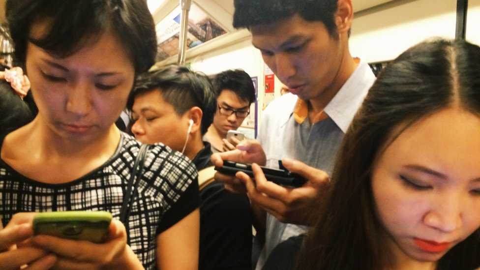 gente en el metro usando celular