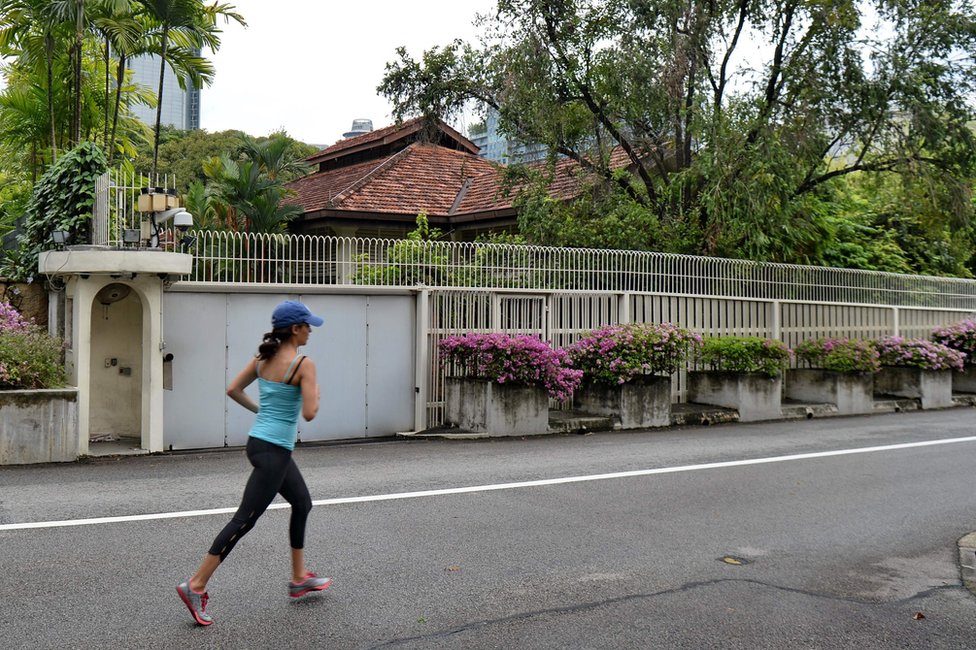 Женщина пробегает мимо дома покойного премьер-министра Сингапура Ли Куан Ю на Оксли-роуд 38 в Сингапуре 3 июля 2017 года.