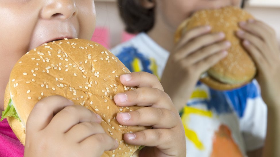 Niños comiendo hamburguesas