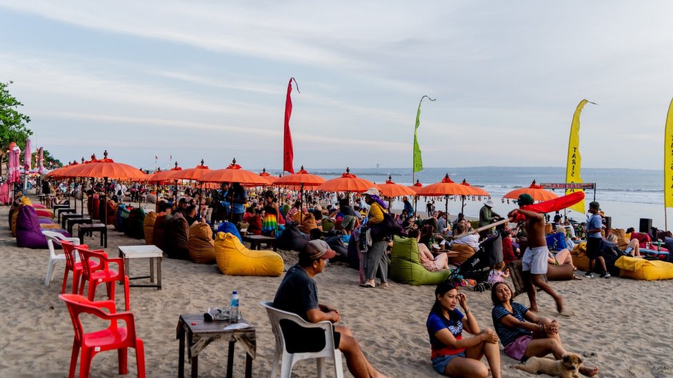 People hang out during evening hours at Seminyak Beach. Tourism in Indonesia is picking up after the covid 19 pandemic. The government has attempted to revive tourism by lowering or removing all entry requirements for foreign tourists