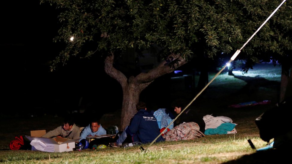 Люди накрываются одеялами, готовясь провести ночь на открытом воздухе после землетрясения в Аматриче