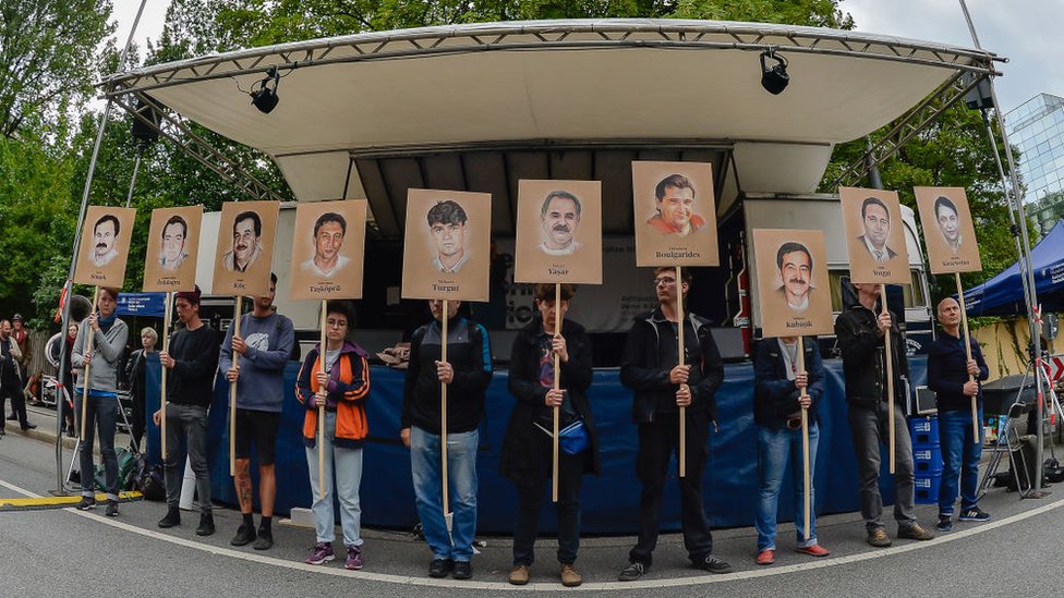 Manifestantes sostienen carteles con los retratos de las víctimas del grupo terrorista neonazi alemán Clandestinidad Nacionalsocialista (NSU).