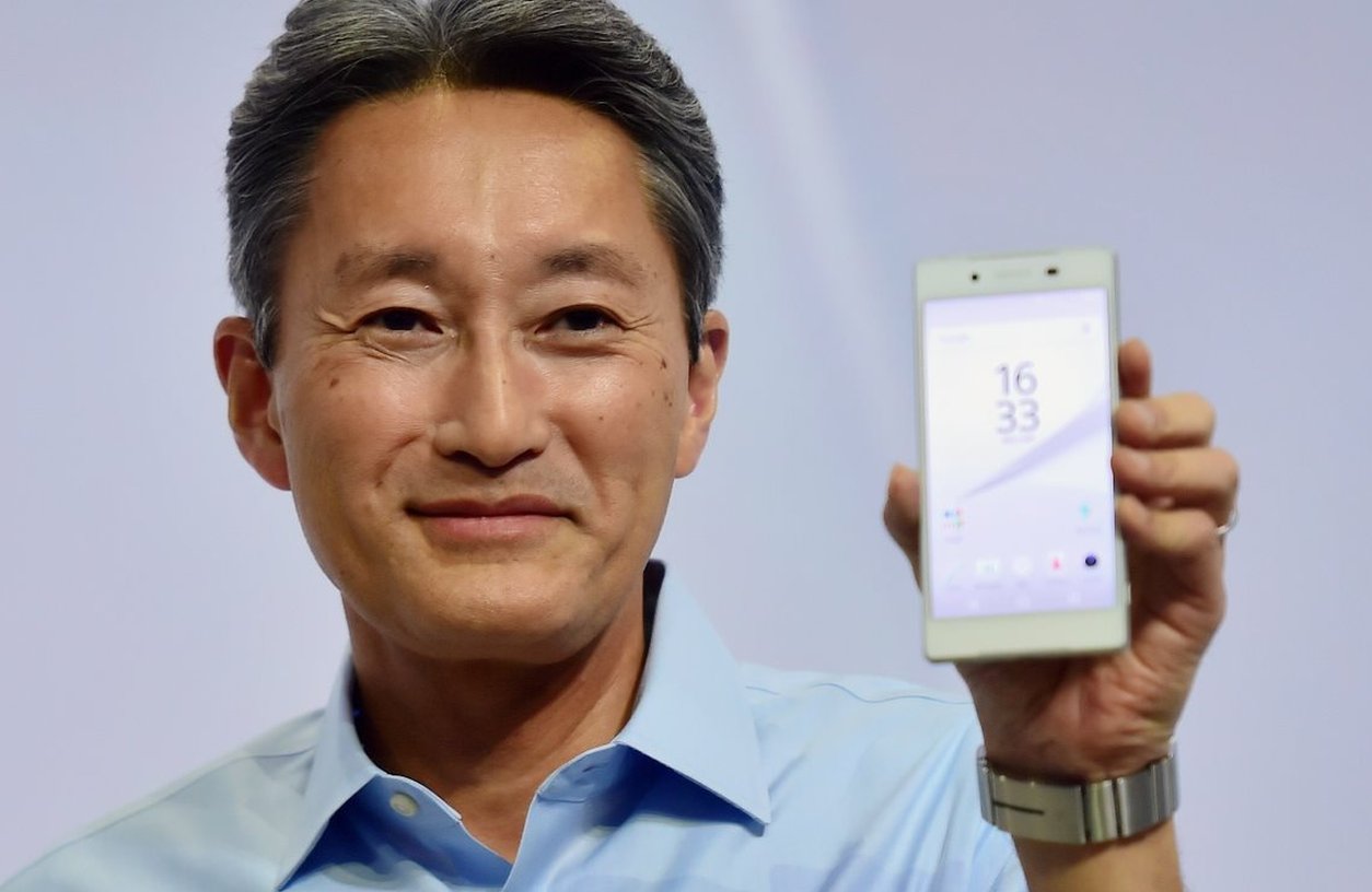 Кадзуо Хираи держит телефон Sony Xperia