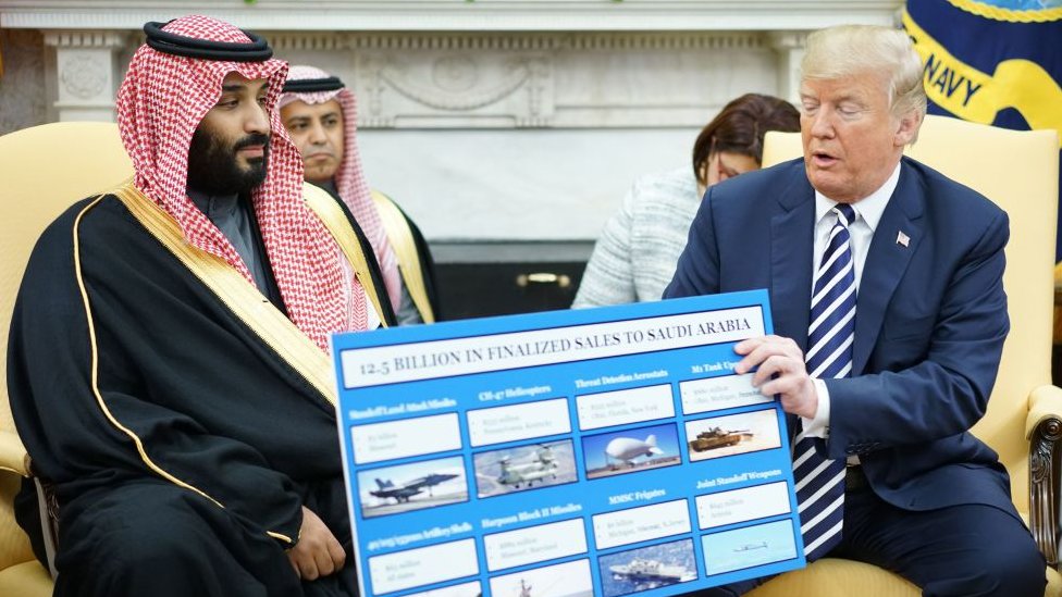 Donald Trump (der.) sostiene un cartel con la descripción de las ventas de armas junto al príncipe heredero de Arabia Saudita, Mohammed bin Salman, en la Casa Blanca, 20 de marzo de 2018