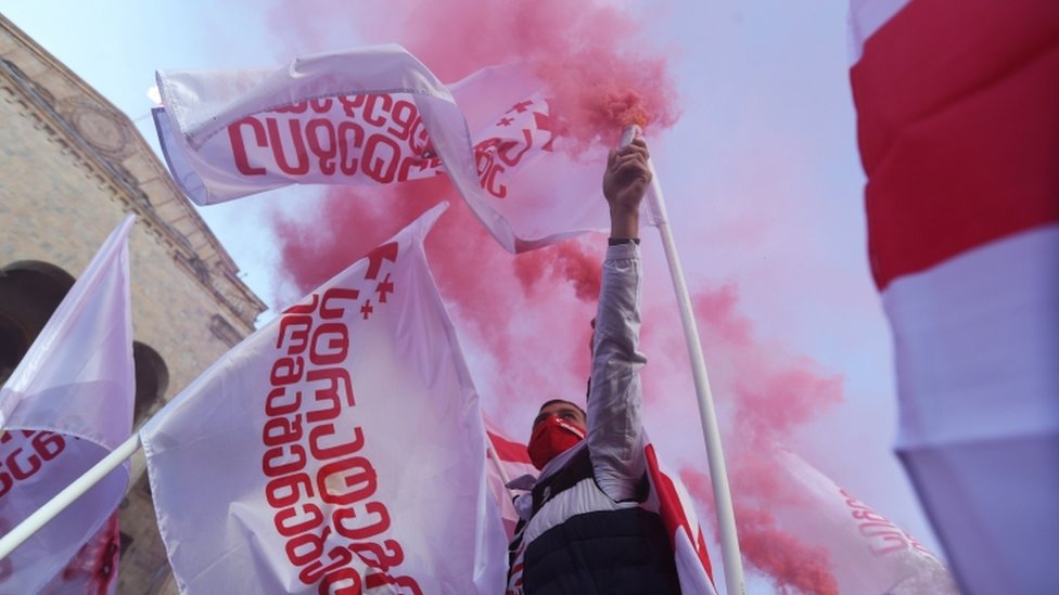 Сторонник оппозиции держит шашку во время митинга против результатов парламентских выборов в Тбилиси, Грузия