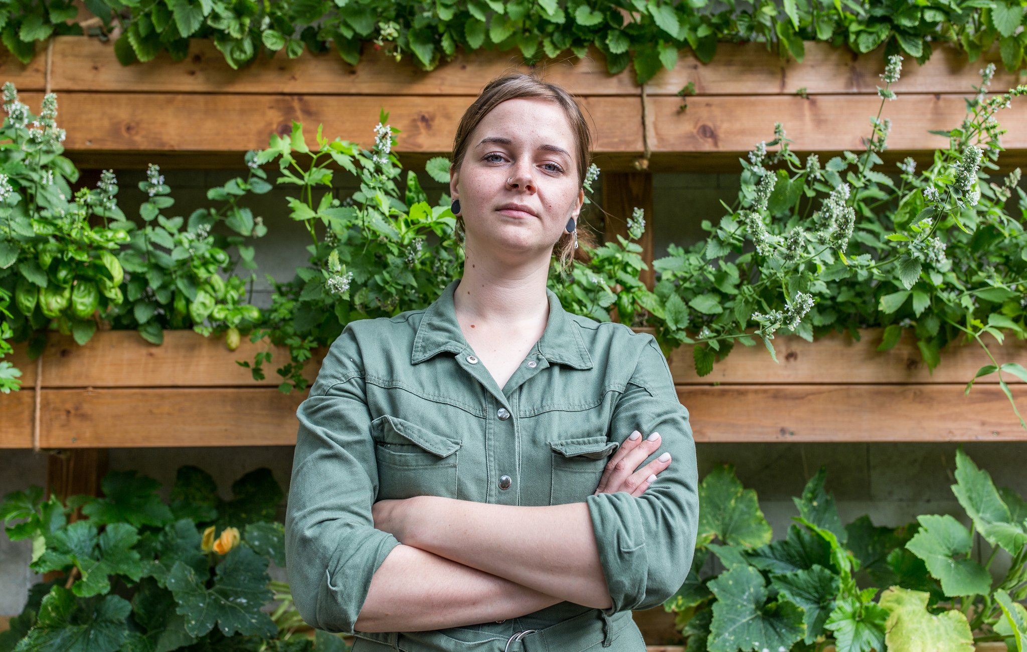 Viktoria Mosina, chef at Grun Cafe, standing in front of her allotment mounted on the wall of the restaurant