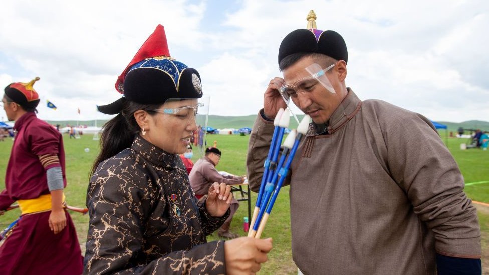 Jueces durante el festival Naadam de Mongolia, cubriéndose los rostros con pantallas protectoras, en julio de 2020.