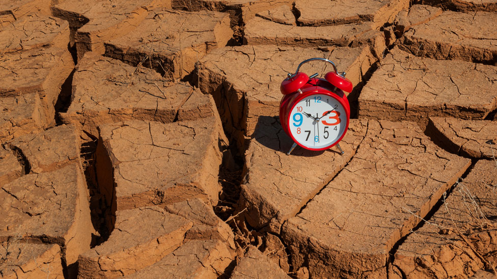 Tierra seca sobre la que hay un reloj