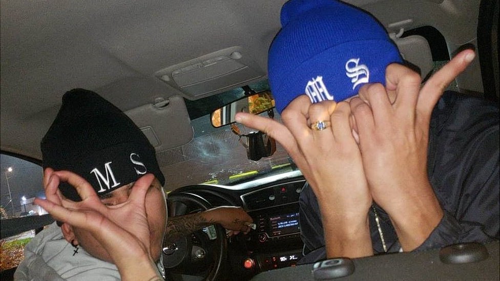 Foto proporcionada por el Departamento de Justicia del Distrito Central de California como parte de la acusación. En ella aparecen dos jóvenes que usan gorros con las letras "MS" bordadas y hacen gestos con sus manos que son característicos de los miembros de la pandilla.