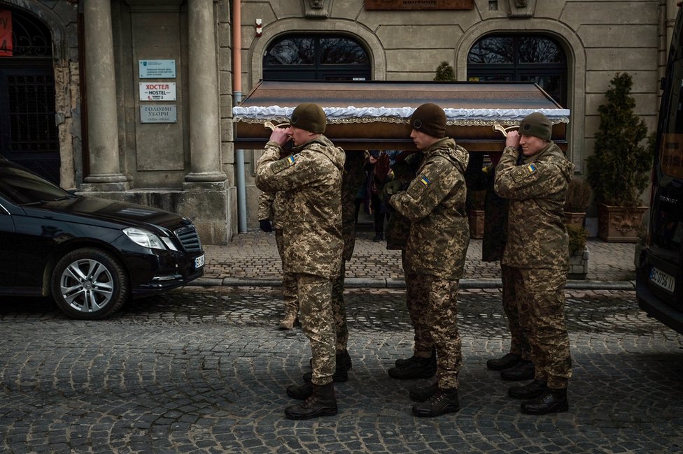 O caixão de Kotenko sendo carregado para o interior da igreja militar em Lviv. Três homens foram enterrados naquele dia.