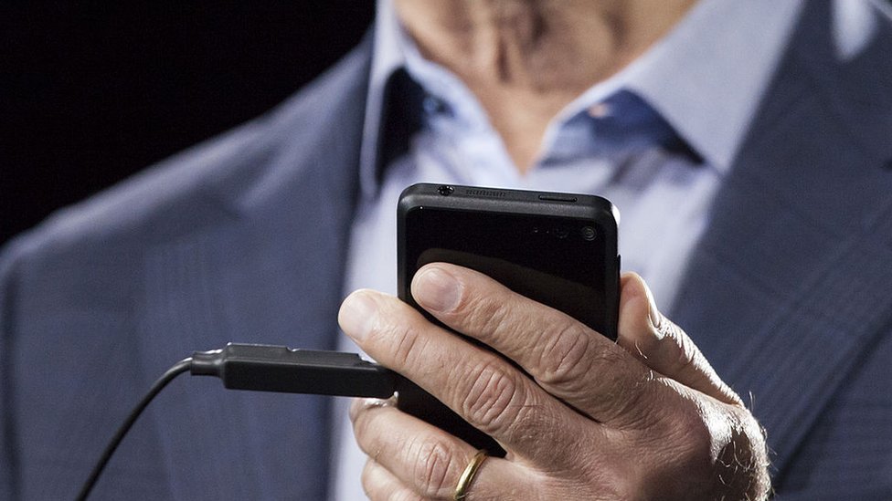 Jeff Bezos sosteniendo un teléfono, 2014
