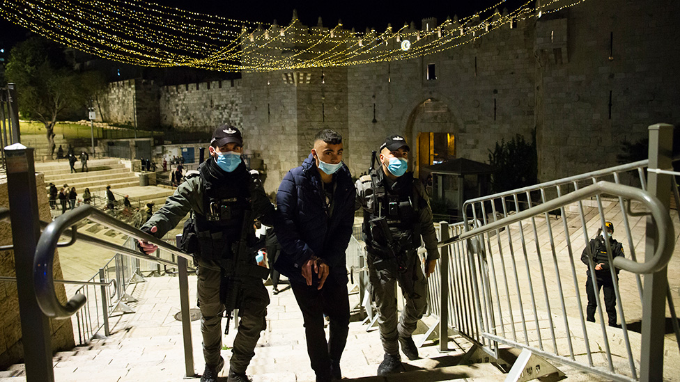 Israeli police officers detain a young Palestinian man at the Damascus Gate