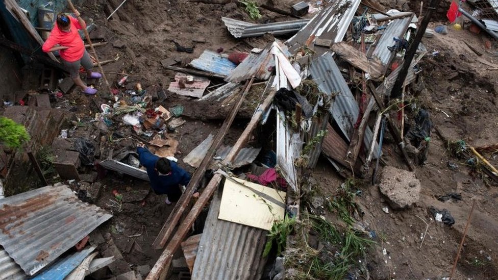 Женщина и ее сын смотрят на завалы после того, как их дом был разрушен разливом ручья из-за проливных дождей, вызванных прохождением тропического шторма Аманда в Сан-Сальвадоре 31 мая 2020 года.