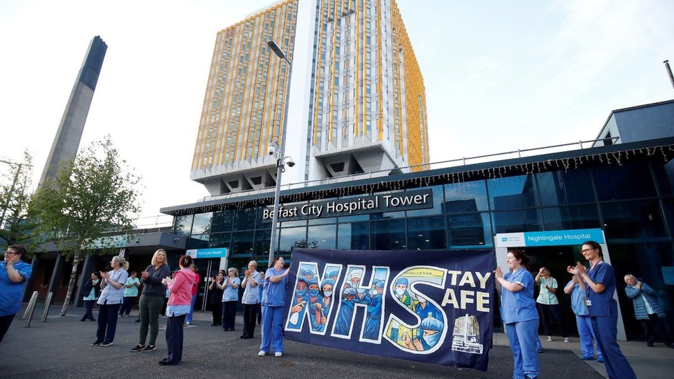 Сотрудники NHS с транспарантом реагируют в больнице Nightingale во время кампании «Хлопок для наших опекунов» в мае в поддержку NHS