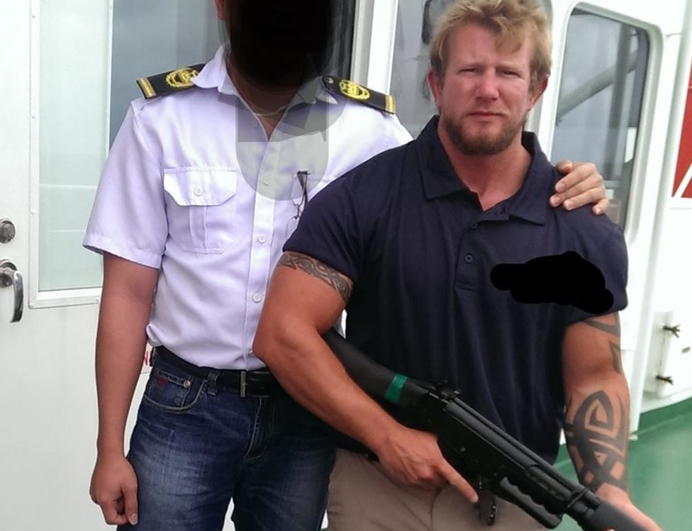 Ник Данн держит пистолет рядом с офицером корабля