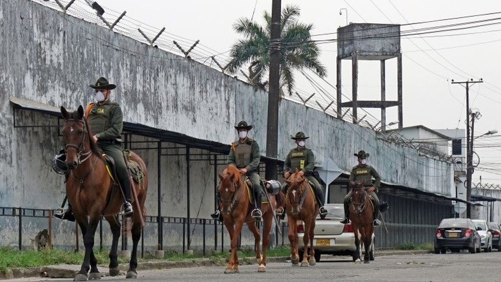 Раздаточная фотография, предоставленная мэрией Вильявисенсио, показывает группу полицейских, патрулирующих внешнюю территорию тюрьмы Вильявисенсио в Вильявисенсио, Колумбия, 21 марта 2020 г.