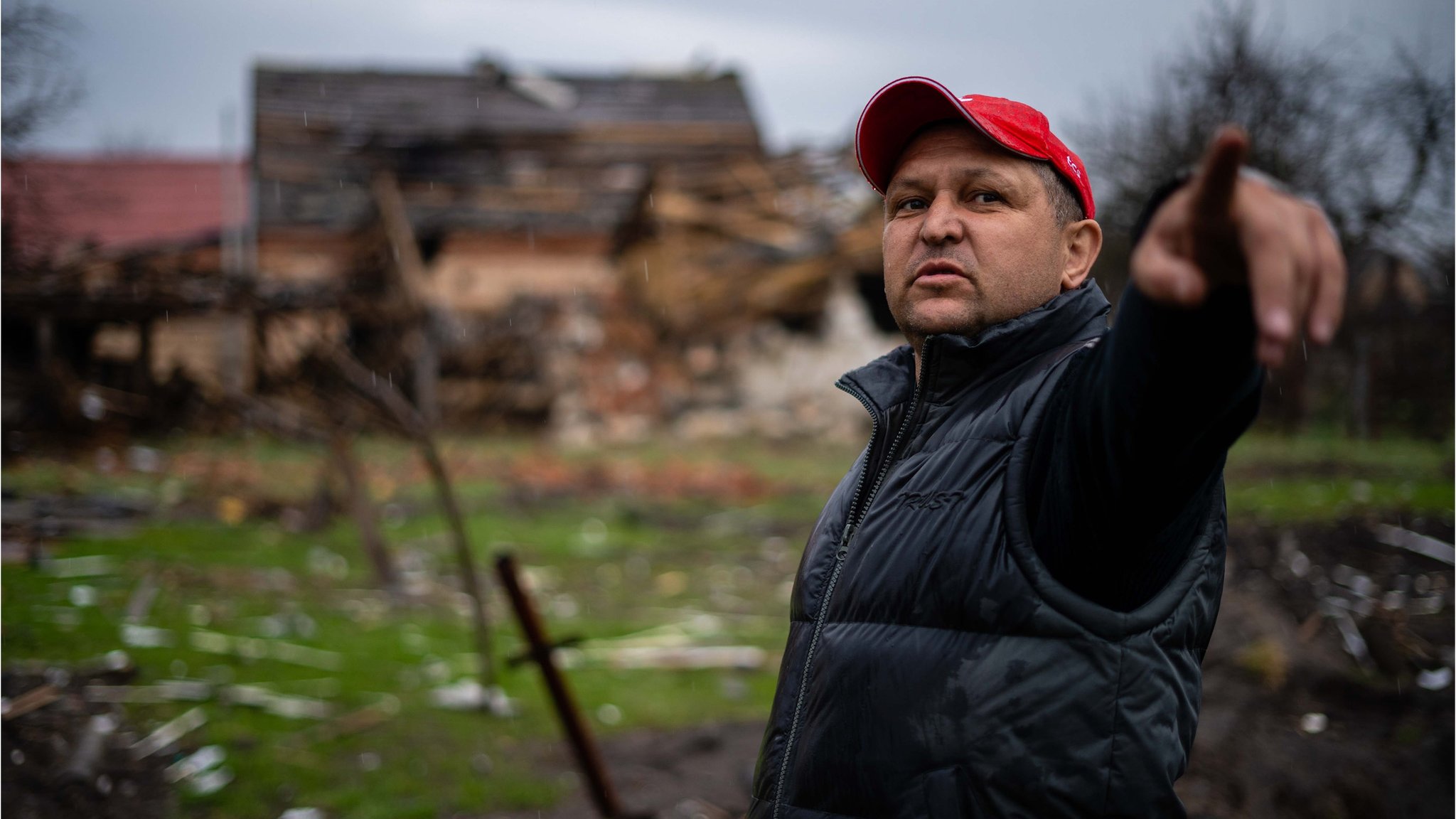 A civilian north of Kyiv points to where Russian forces destroyed his home