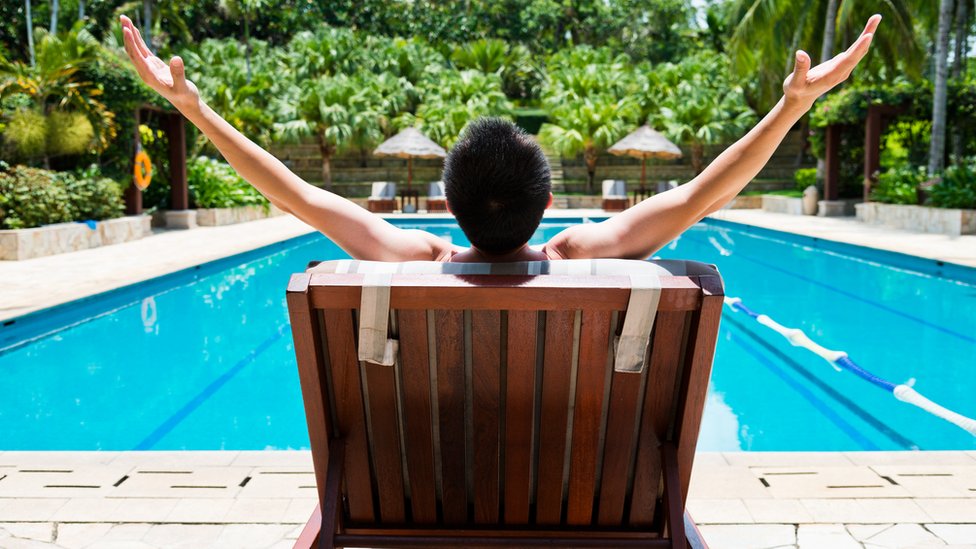Hay más millonarios que millonarias. Hombre mirando a una piscina.