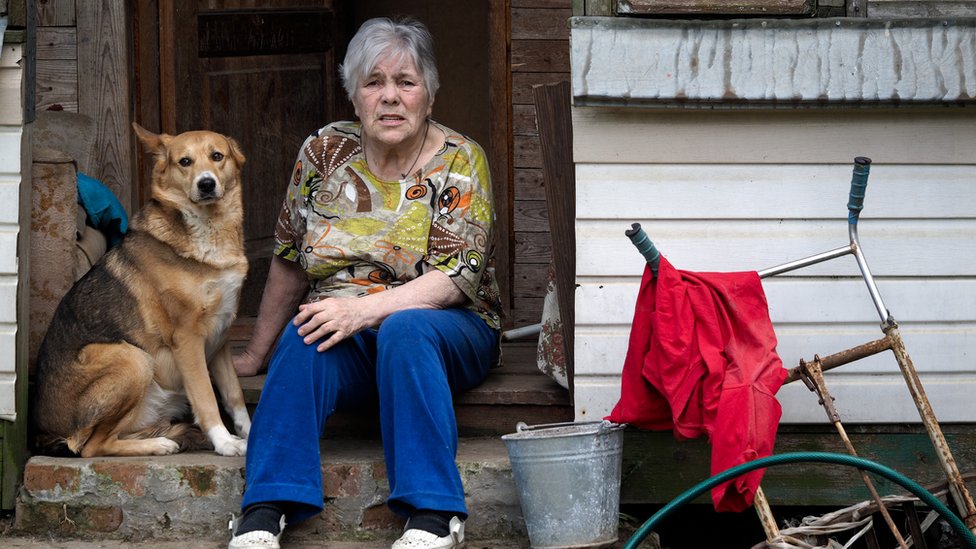 Mujer con un perro en la puerta de su casa