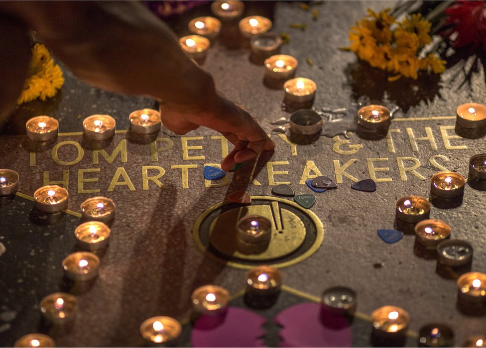 A man touches the Tom Petty and the Heartbreakers star on The Hollywood Walk of Fame after Petty suffered a massive heart attack last night that left him in very grave condition, on October 2, 2017