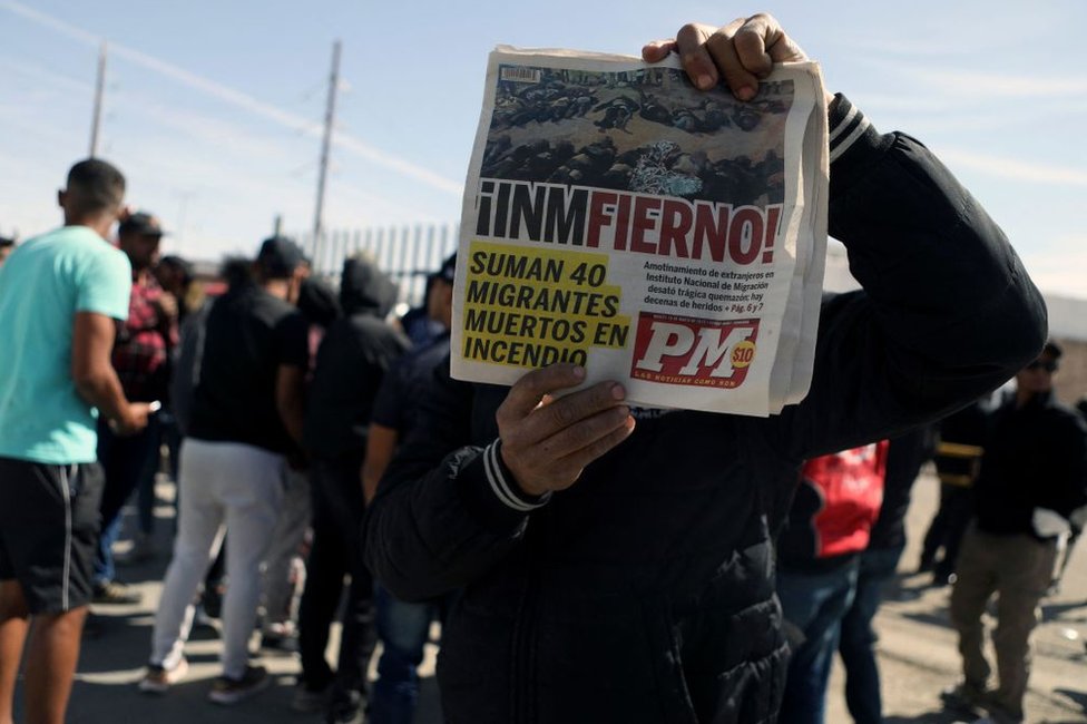 Hombre sostiene un periódico que anuncia la tragedia de Ciudad Juárez en la que murieron al menos 40 migrantes en un centro de detención el 28 de marzo de 2023.