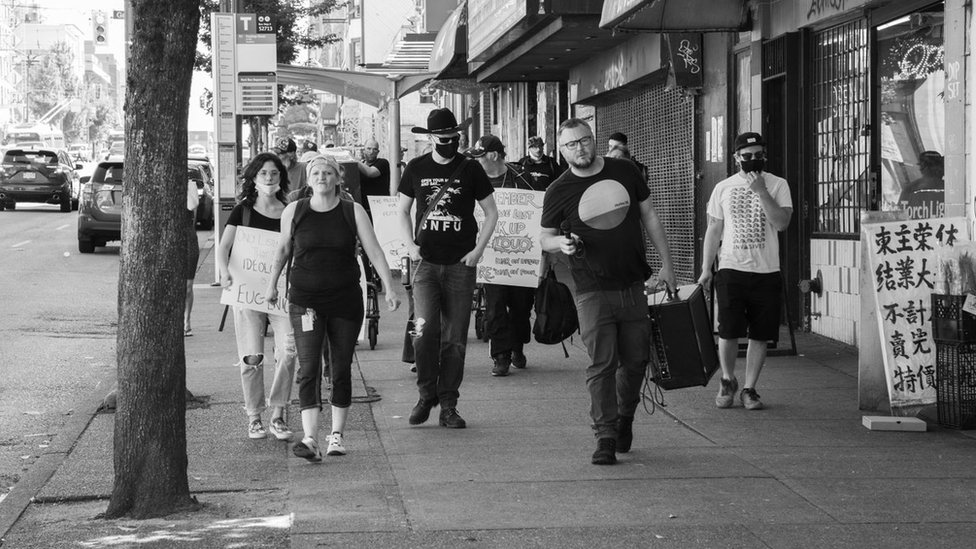 Участники августовского марша памяти жертв кризиса передозировки проходят по улицам Ванкувера