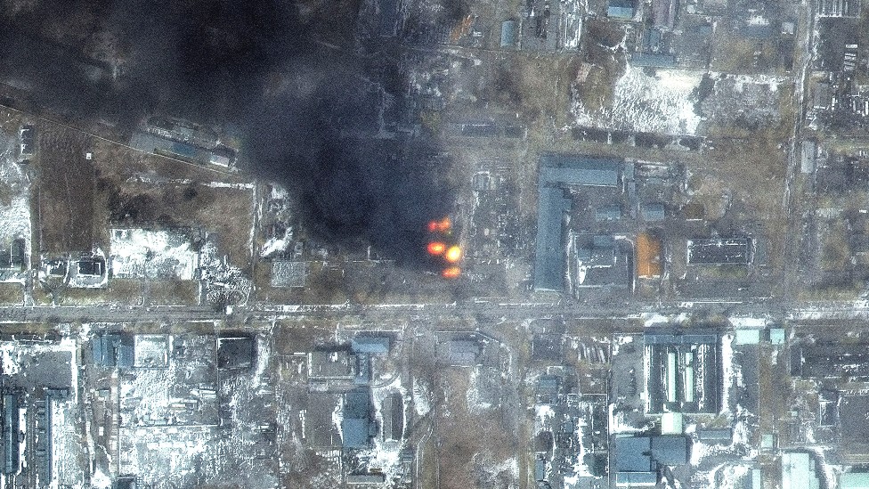 Vista desde un dron de la devastación en Mariúpol, se ve un incendio y edificios pulverizados