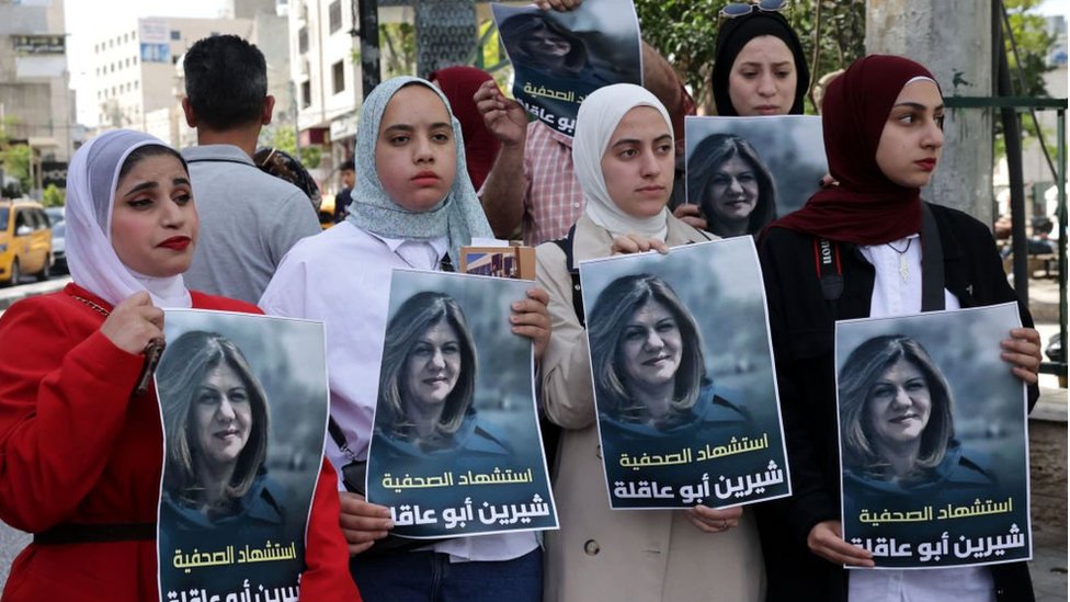 Demonstran Palestina memegang foto Shireen Abu Aqla.