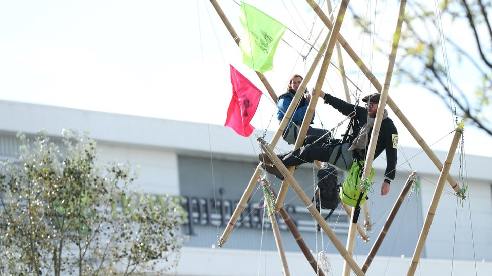 Протестующие прикованы цепями к бамбуковым конструкциям возле прессов в Хартфордшире