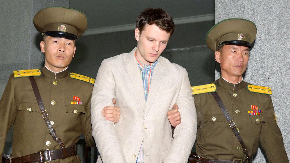 Otto Warmbier, iki Kuzey Koreli asker tarafından götürülürken (Mart 2016).