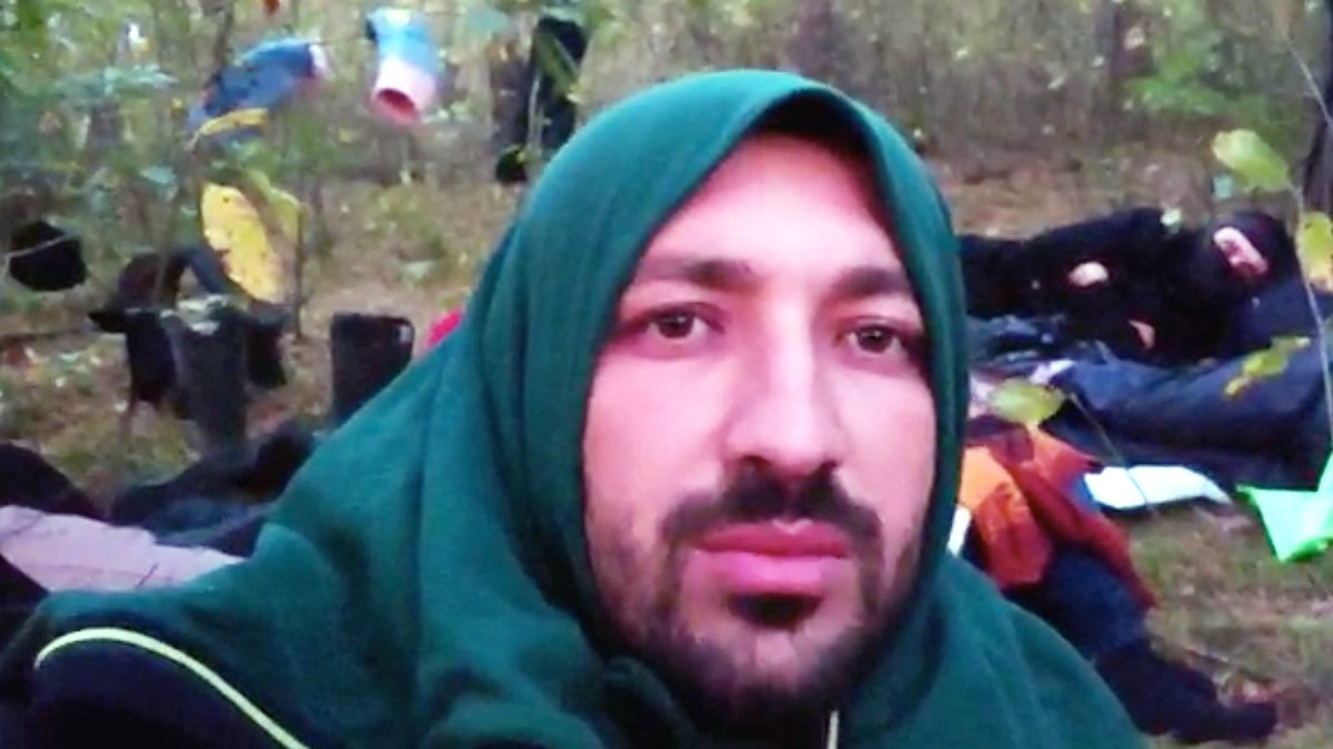 Idris - his head covered to keep warm - records a video in the forest