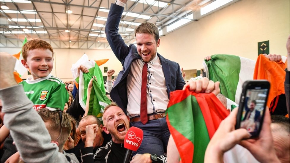 Доннчад O Лаогер из Sinn Fein празднует то, что он стал первым TD, избранным на 33-е место, возглавив опрос, опередив Михаила Мартина в пробке