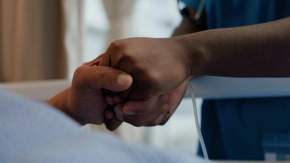 Medicinska sestra drži ruku pacijenta u bolnici
