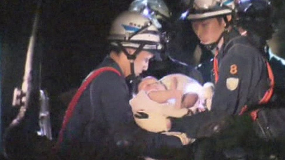 An eight-month-old baby girl is rescued from a collapsed house in Mashiki, Japan. 14th April 2016.