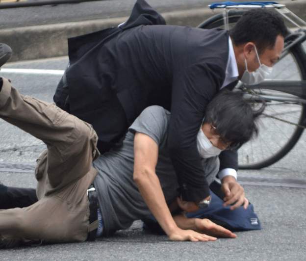 Tetsuya Yamagami es subyugado por un agente de seguridad.