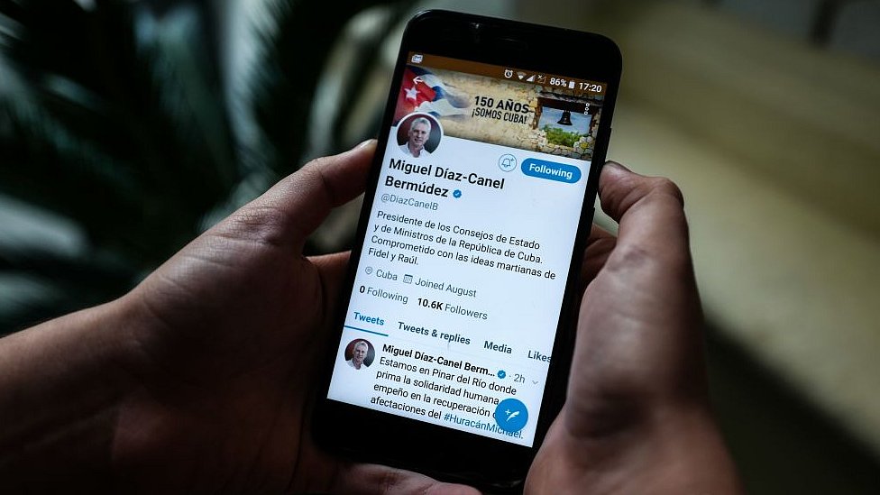 Человек держит смартфон, на котором изображен твиттер-аккаунт президента Кубы Мигеля Диас-Канеля, в Гаване, 10 октября 2018 г.