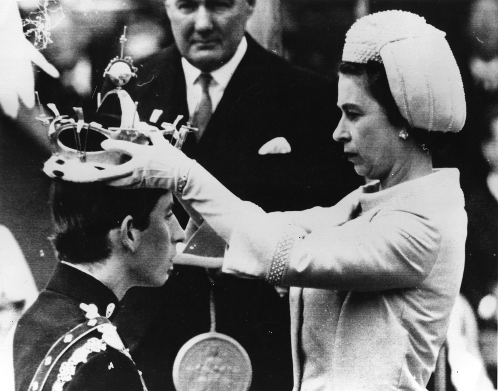 La reina Isabel II coloca la corona en la cabeza de Carlos, príncipe de Gales, durante su ceremonia de investidura.