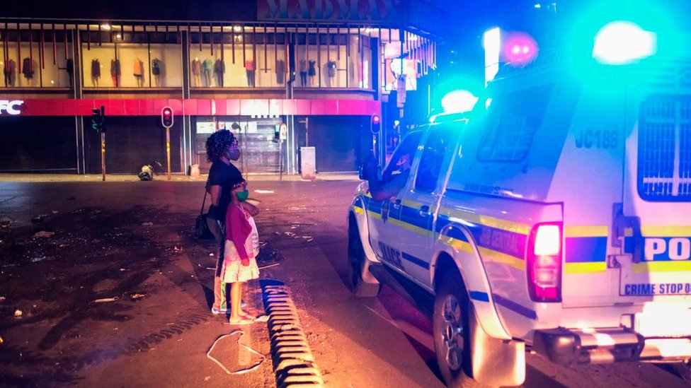 امرأة وطفل يشرحان لضابط شرطة جنوب إفريقيا سبب وجودهما في الشارع أثناء حظر التجول في ديسمبر/كانون الاول 2020