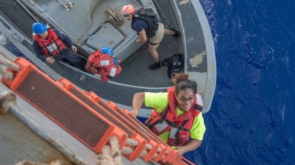 Las dos mujeres y sus perros sobrevivieron gracias a que tenían almacenados alimentos secos y un purificador de agua. Una mujer subiendo por un barco