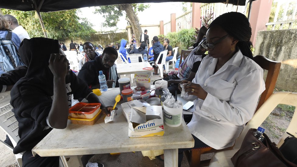 Мигранты обращаются к чиновникам здравоохранения вскоре после возвращения из Ливии в Бенин-Сити, Нигерия