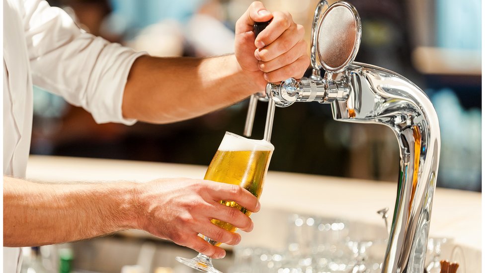 Изображение мужчины, разливающего напиток в баре