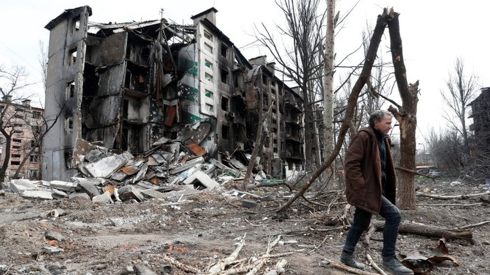 Man walking near a residential building in Mariupol.