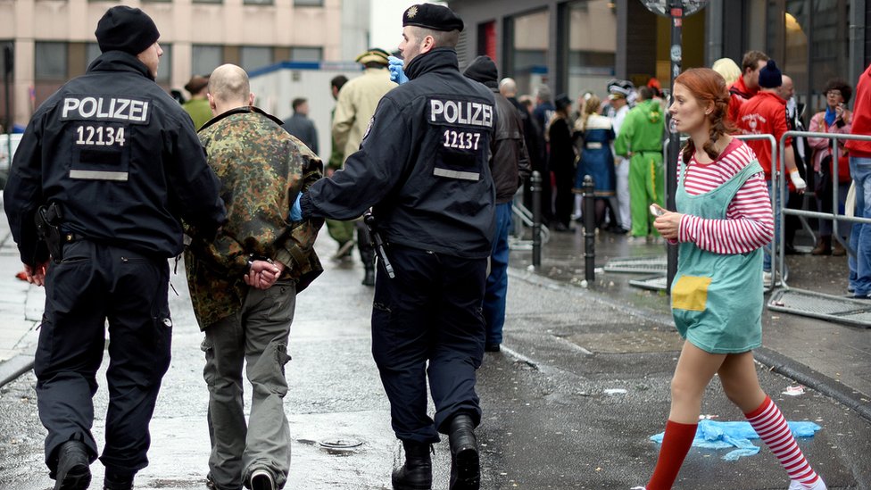 Полицейские арестовывают мужчину во время празднования Weiberfastnacht в рамках карнавального сезона 4 февраля 2016 года в Кельне, Германия.