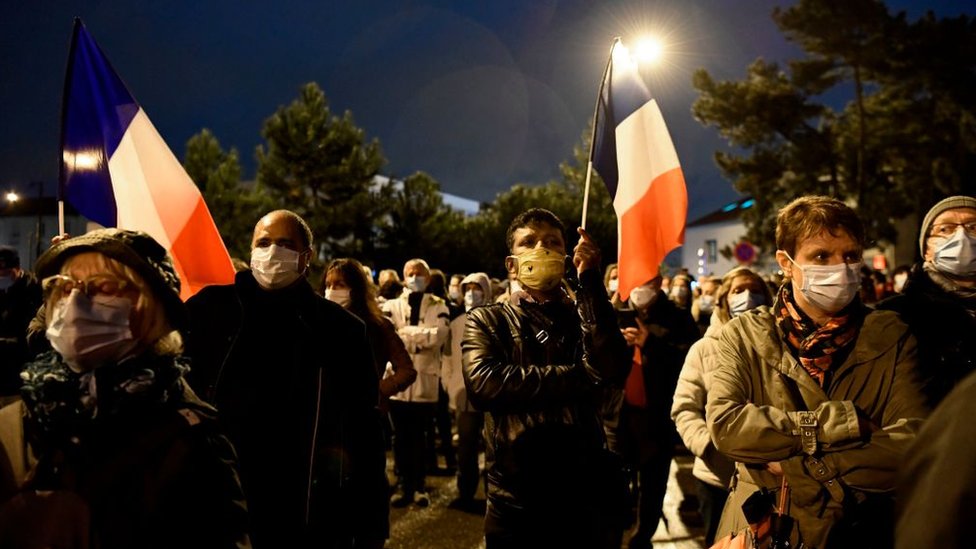 People attend a memorial march in Conflans-Sainte-Honorine, northwest of Paris