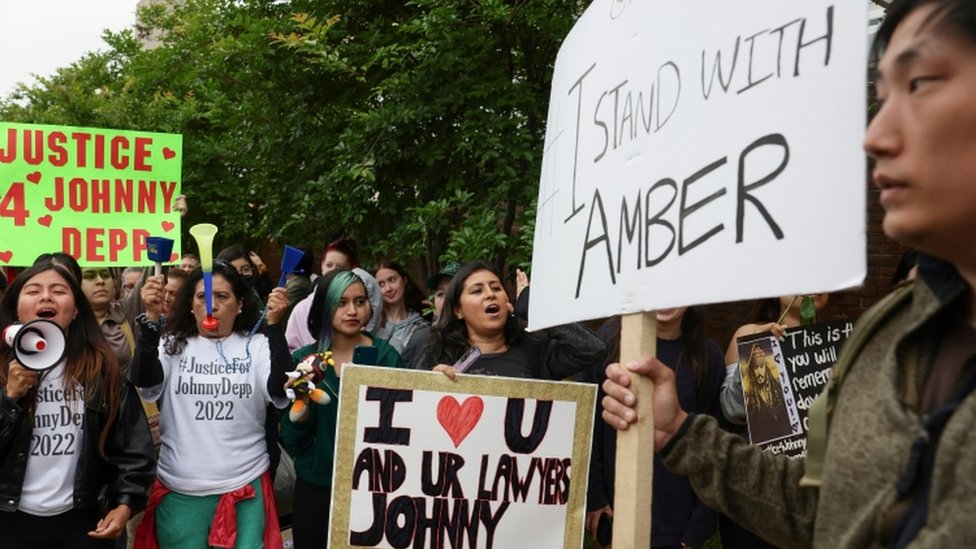 Personas a las afueras de la corte con carteles a favor de Amber Heard y de Johnny Depp