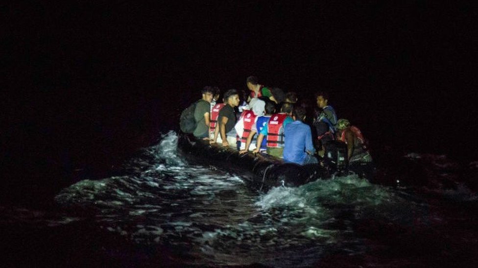 A rubber dinghy full of migrants crossing to the Greek island of Lesbos at night