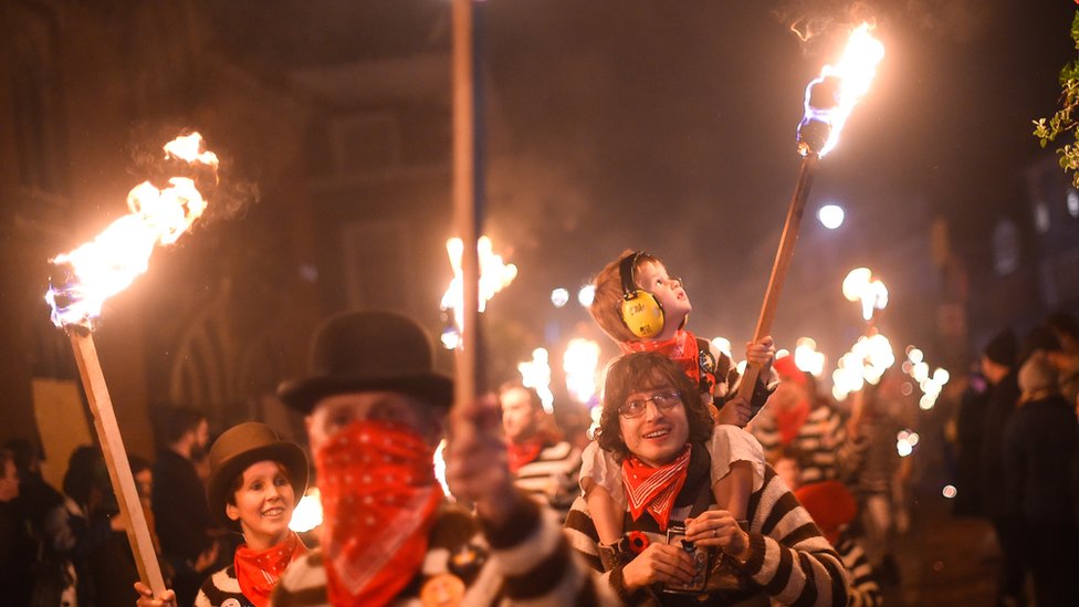 Общества костра проходят по улицам во время традиционного празднования Ночи костра