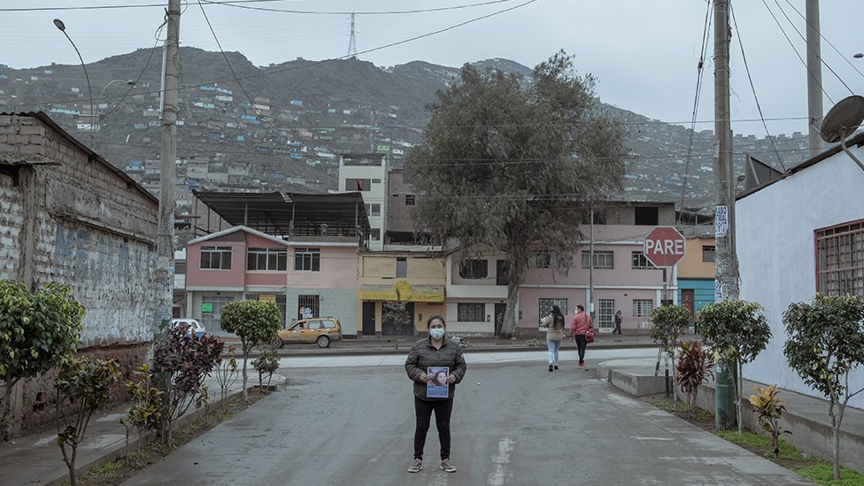 Джессика Кесада (30) несет фотографию своей невестки Элисон Фернандес (30), которая вышла на местный рынок утром 13 августа и не вернулась домой