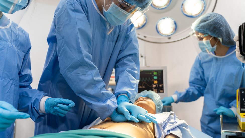 Um médico realizando ressuscitação cardiopulmonar em um paciente