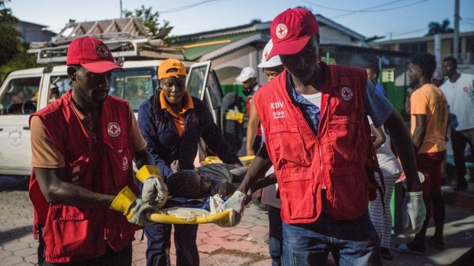 Red Cross paramedics carry a girl injured during a 7.2 magnitude earthquake in Les Cayes,